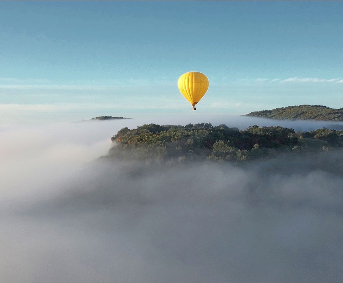 une montgolfière s'envole au dessus des montagnes